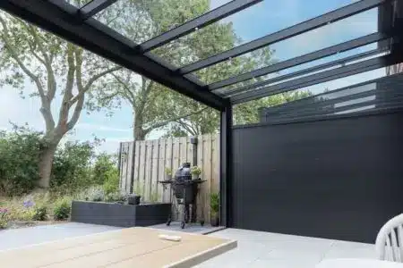 Glass veranda with clear roof panels and privacy aluminium side wall