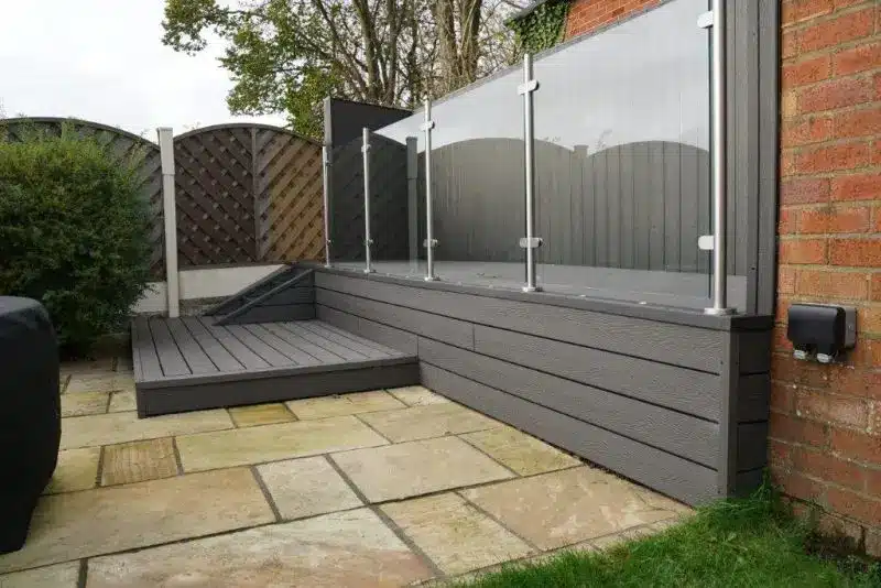 Raised composite decking with glass balustrade and steps.