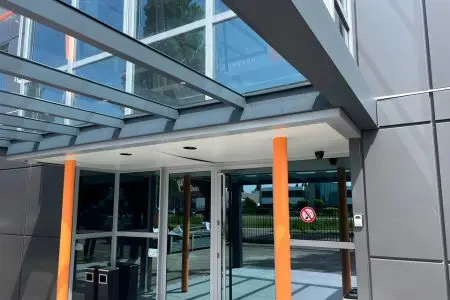 Front view of a modern Sturmer glass veranda installed over a building entrance.