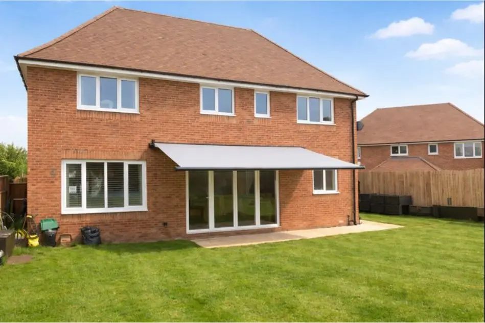 Weinor awning installed on a brick-built family home with extended garden lawn