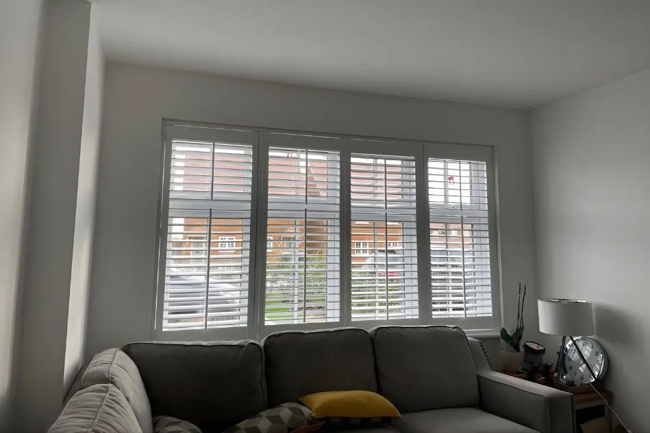 White plantation shutters fitted to living room window